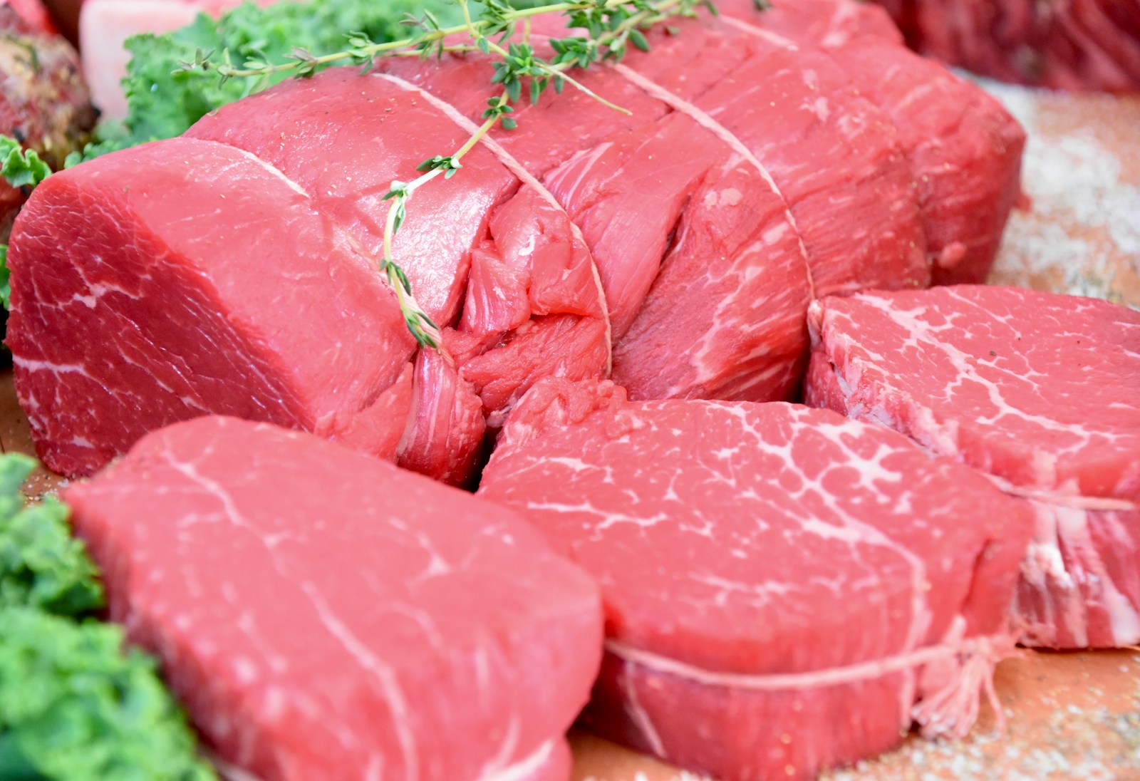 sliced raw meat on brown wooden table